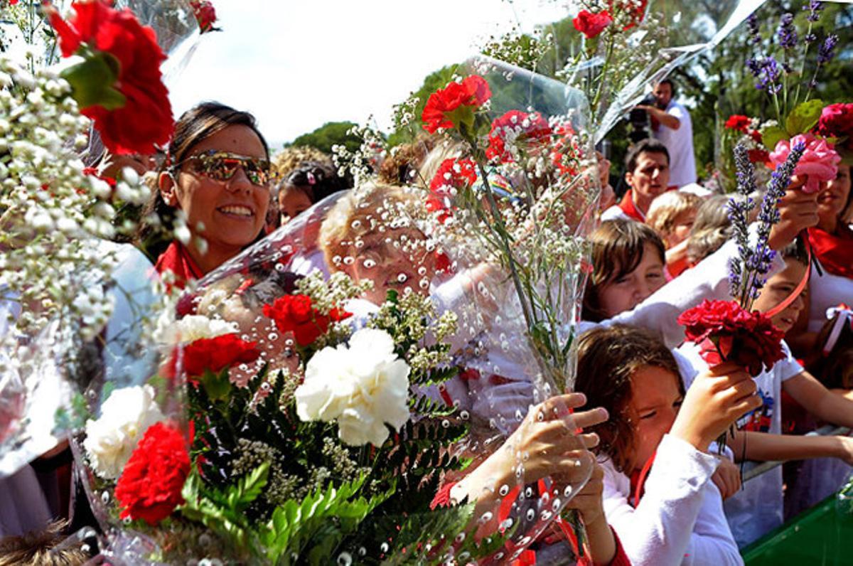 Centenars de nens acompanyats pels seus pares i avis aixequen rams de flors per beneir-los abans d’oferir-los a sant Fermí, a Pamplona.