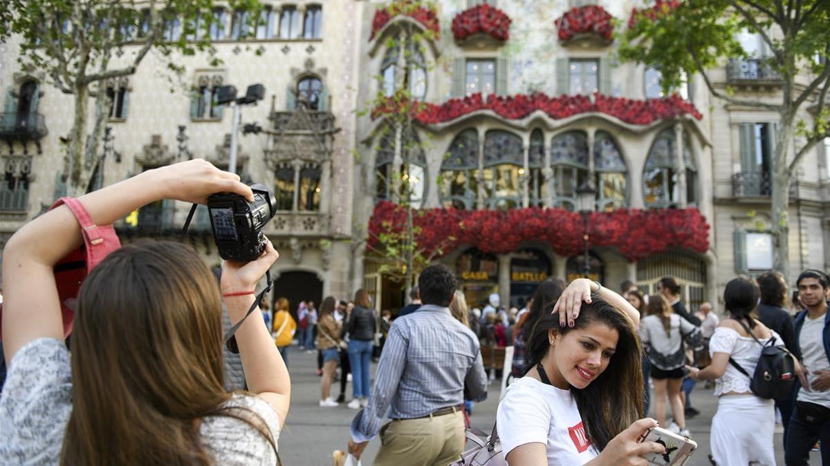 Decenas de flores decoran la fachada de la Casa Batllo horas antes de la 'diada' de Sant Jordi.