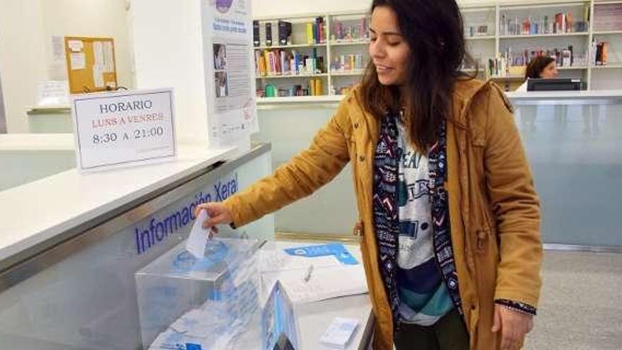 Una estudiante deposita su donación en horas. // Duvi