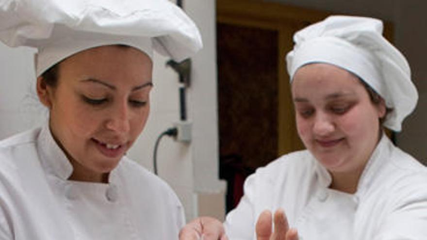 Dos alumnas gijonesas, tamizando harina.