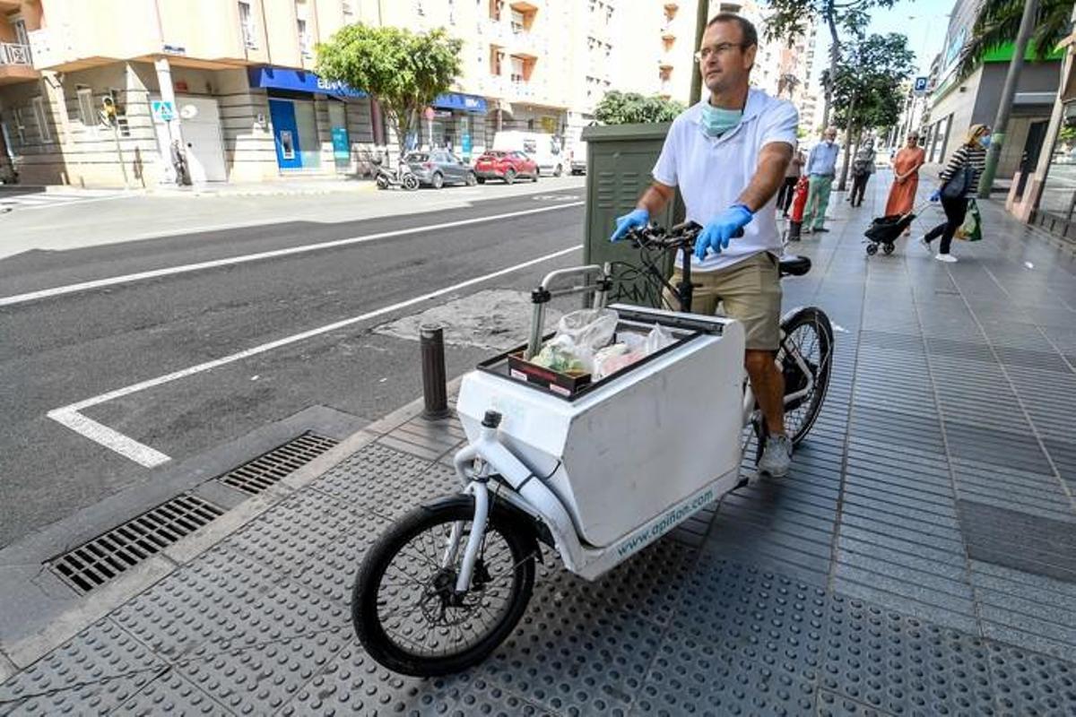 29-04-20  LAS PALMAS DE GRAN CANARIA. CIUDAD. LAS PALMAS DE GRAN CANARIA. Fotos del dia. Este señor reparte la compra a personas que tienen movilidad reducida llevandoles la compra  en el  vehiculo de su empresa llamada Apiñon, se ha tenido que reconvertir pasando de llevar a turistas de los cruceros al reparto. Fotos: Juan Castro.  | 29/04/2020 | Fotógrafo: Juan Carlos Castro