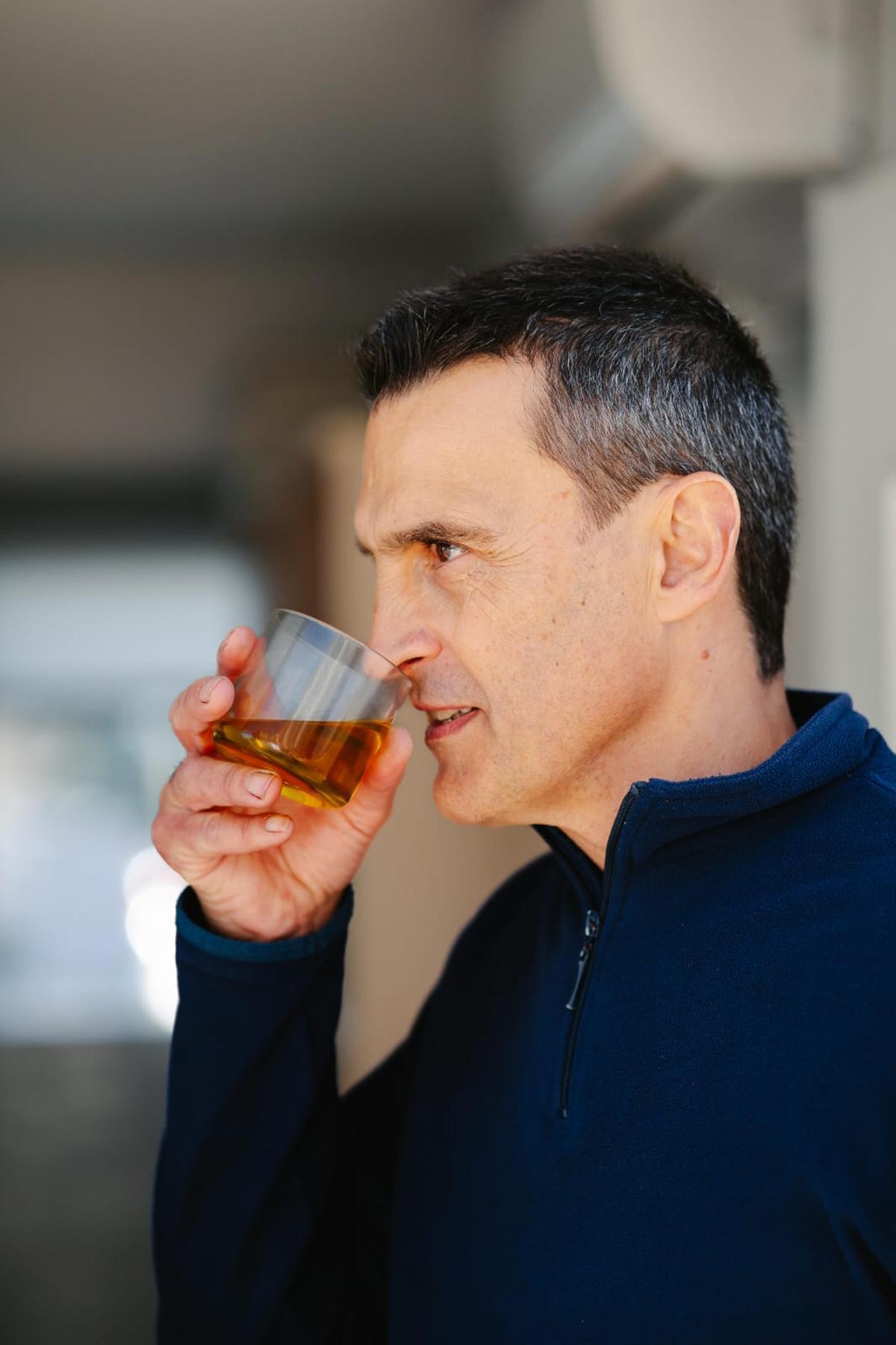 El gerente de la cooperativa analiza con el olfato una muestra de aceite.