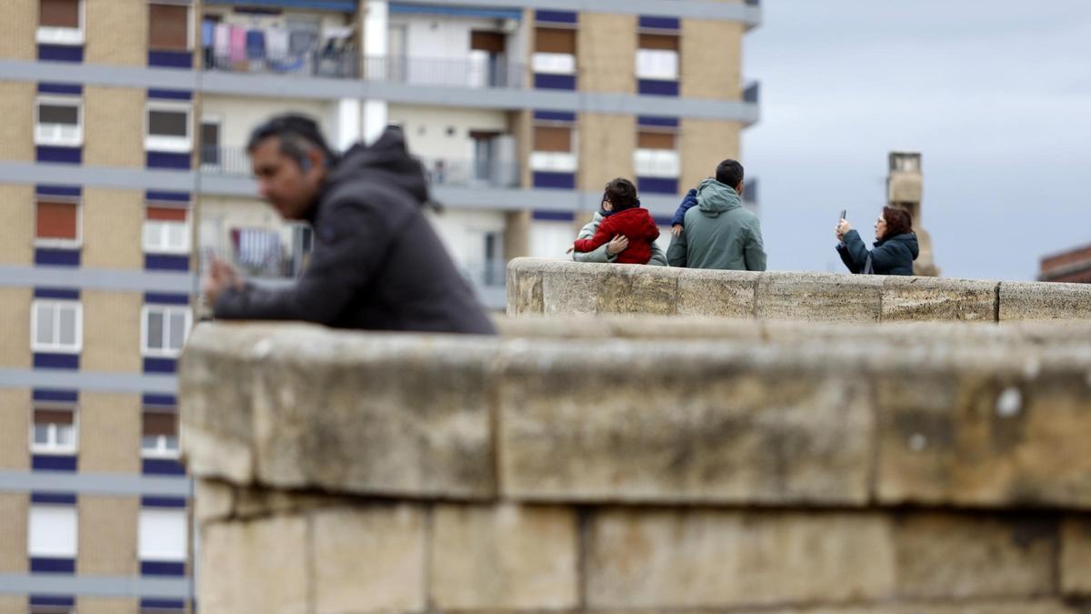 Varios grupos de vecinos en el puente de Piedra de Zaragoza.