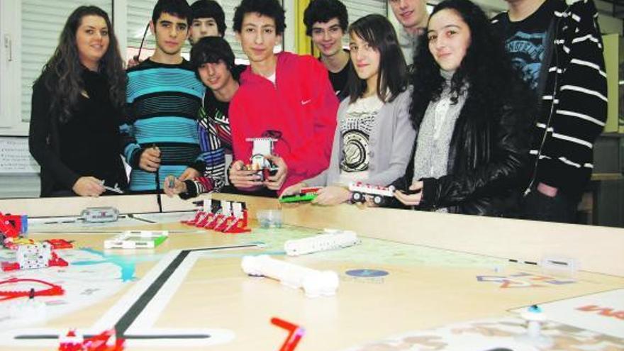 Alumnos del IES de Sama, ante el tablero donde practican las pruebas de robótica.