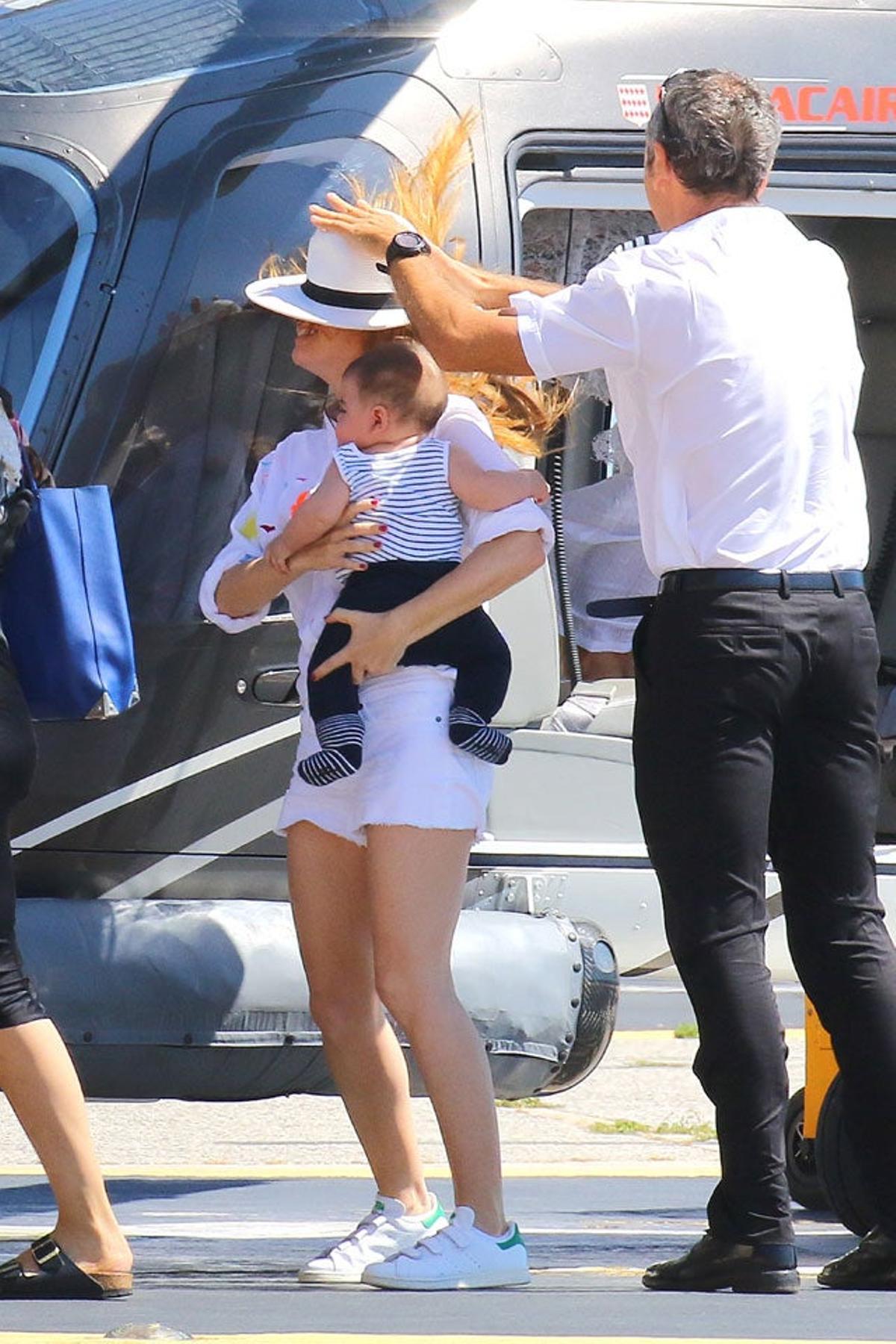 Ayudan a Isla Fisher a colocarse el sombrero que se le está volando con el aire de las aspas