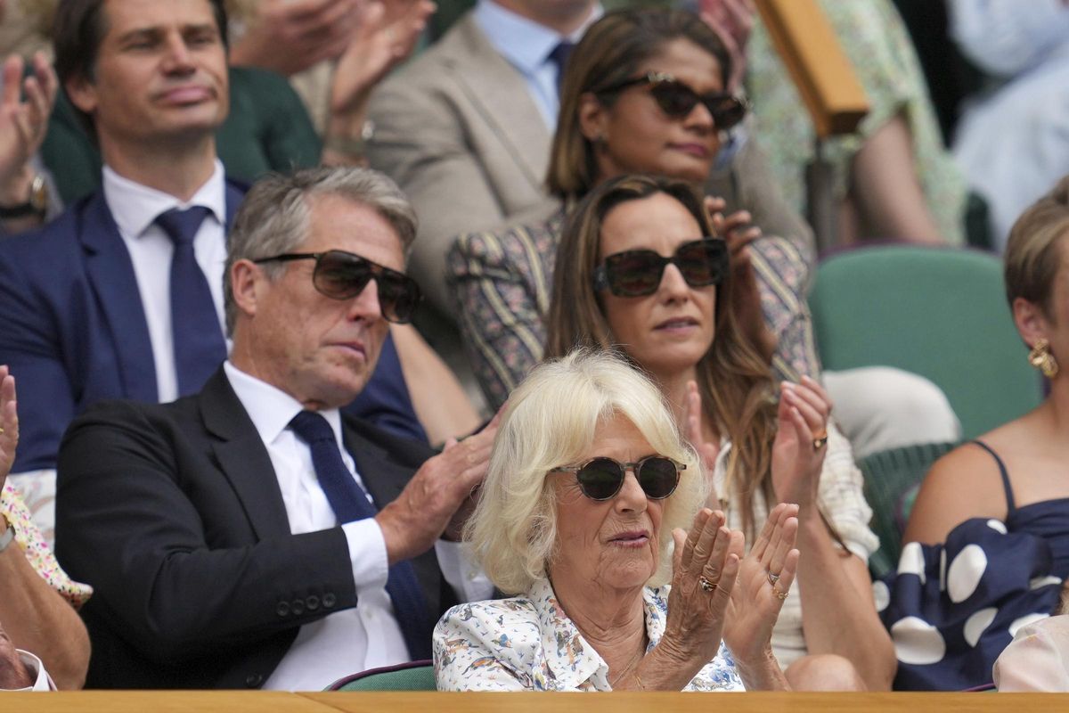 La reina Camilla de Gran Bretaña se sienta frente al actor Hugh Grant y su esposa Anna en el Royal Box on Centre Court el día 10 en el Campeonato de Tenis de Wimbledon
