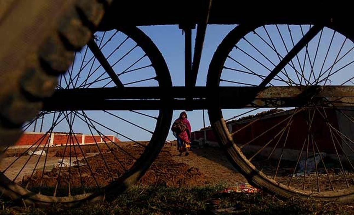 Una dona índia transporta fems després que s’assequi al sol per carregar-lo en un carro a Allahabad (Índia).