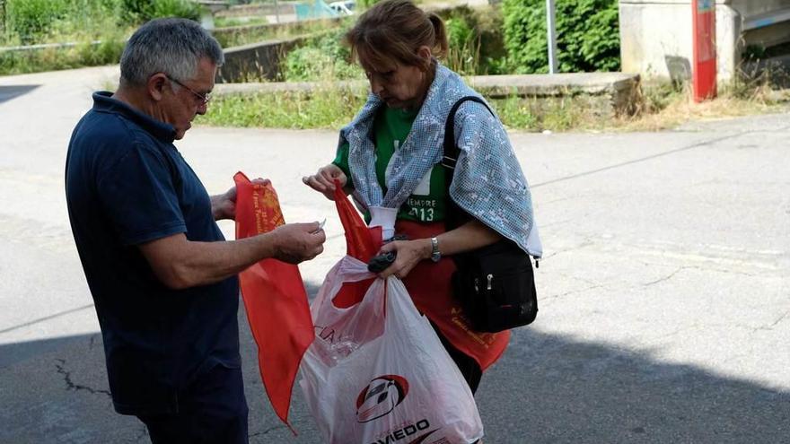 Amparo Pereira, de la asociación &quot;La Fuentina&quot;, vende los pañuelos de la fiesta a los vecinos del pueblo.