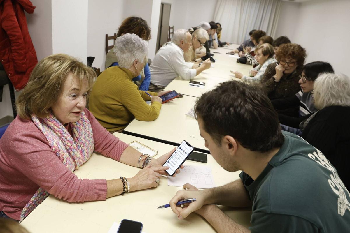 Los mayores participan en el taller de uso de teléfonos móviles.