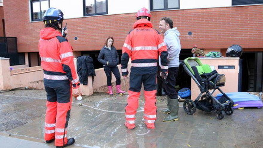 Veïns i Bombers a les cases inundades.