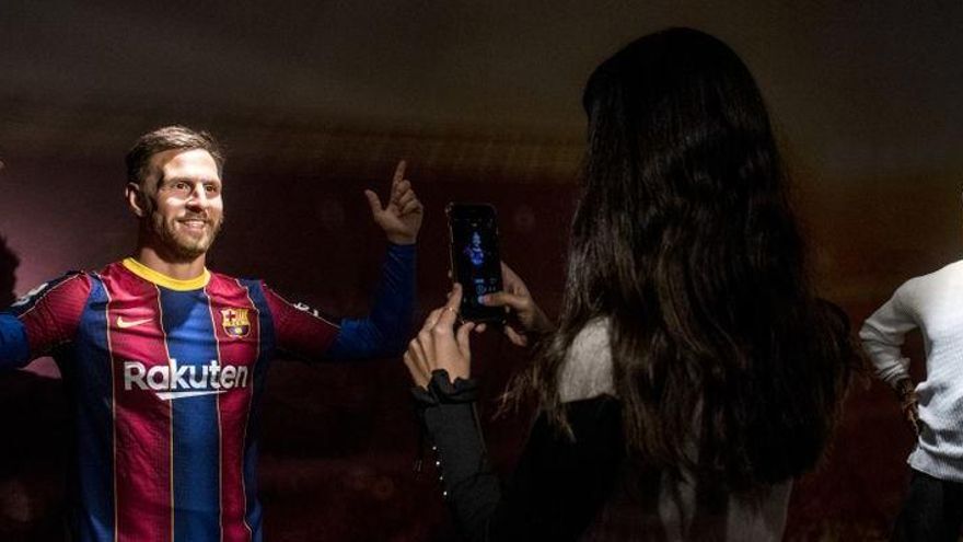 Una dona fa una foto a la figura de cera de Messi