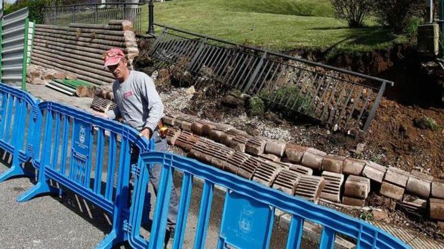 Un operario, colocando vallas de protección, ayer, ante el muro del colegio Germán Fernández Ramos.