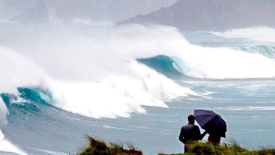 Una persona  se resguarda de la lluvia y el viento. / EFE