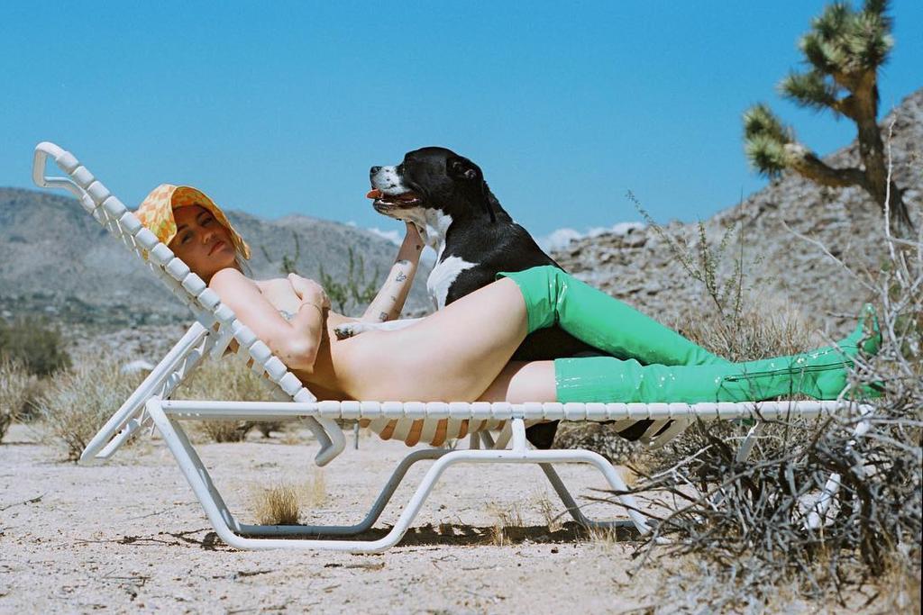 Miley Cyrus desnuda con su perro y botas de plástico