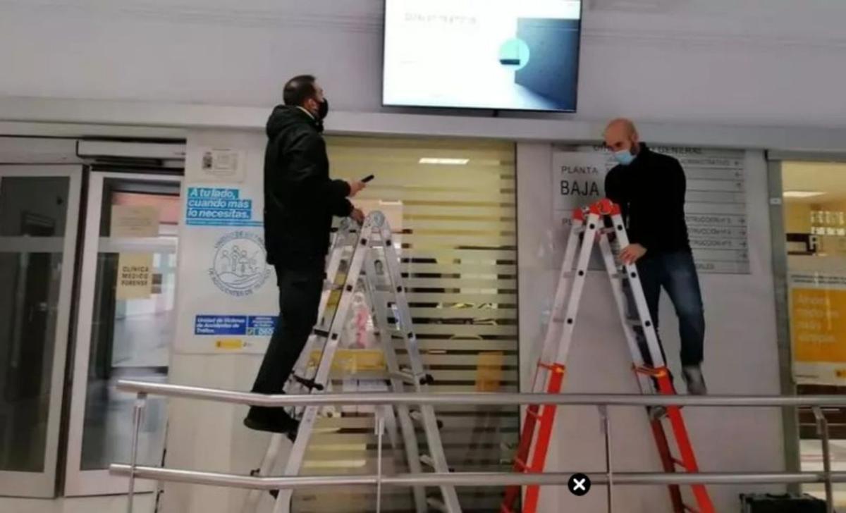 Dos operarios instalan una pantalla sobre la entrada al Registro Civil del Palacio de Justicia de Zamora. | L. O. Z. (ARCHIVO)
