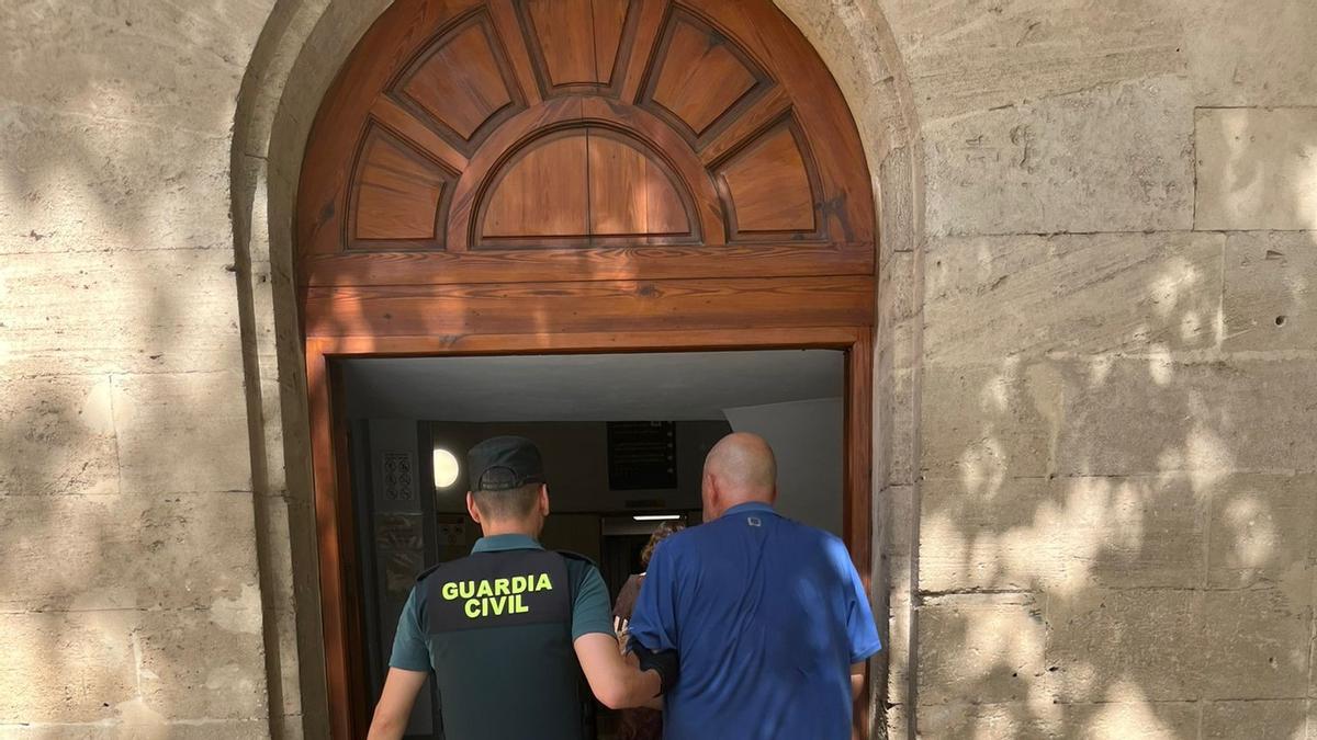 Un guardia civil conduce este lunes al juzgado de guardia al presunto incendiario alemán.