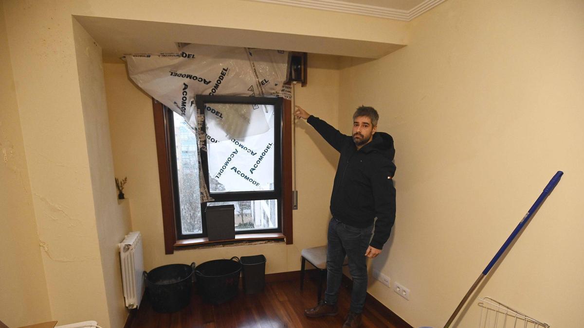 Aitor, uno de los vecinos afectados, enseña el «apaño» realizado para minimizar las afecciones por las filtraciones de agua. / Pablo Hernández Gamarra