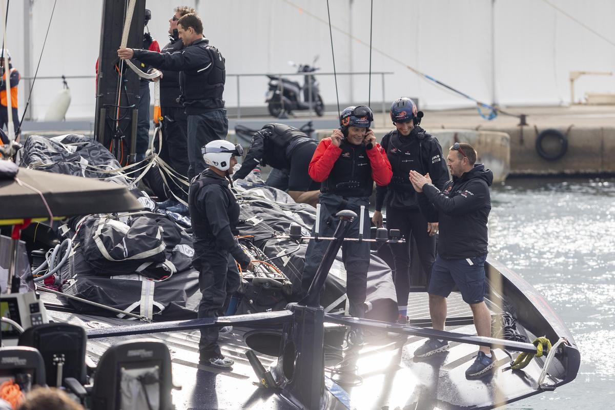 Miembros del equipo Alinghi Red Bull Racing de la Copa América de vela revisan el AC75 tras salir a navegar en Barcelona.