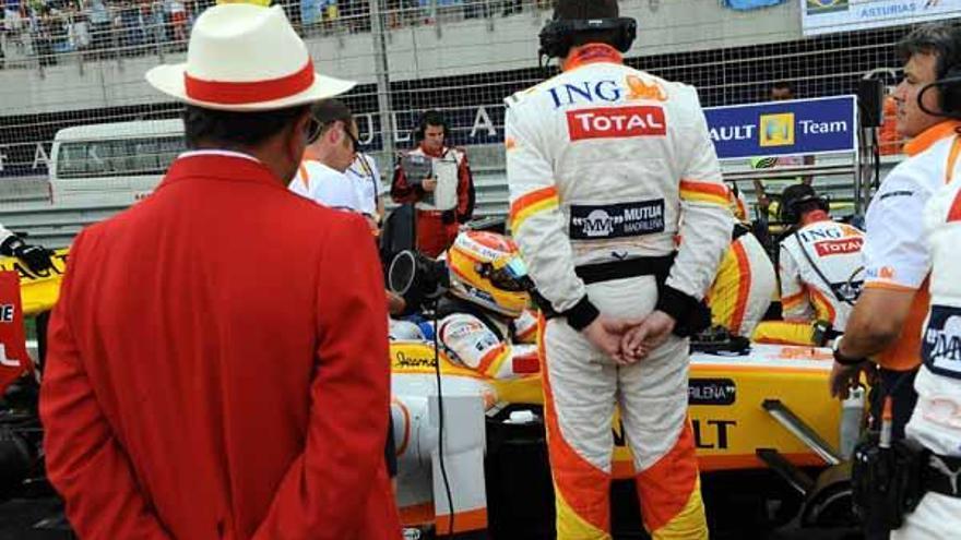 Emilio Botín, de espaldas, observa a Fernando Alonso en su monoplaza antes de iniciarse el Gran Premio de Bahrein.