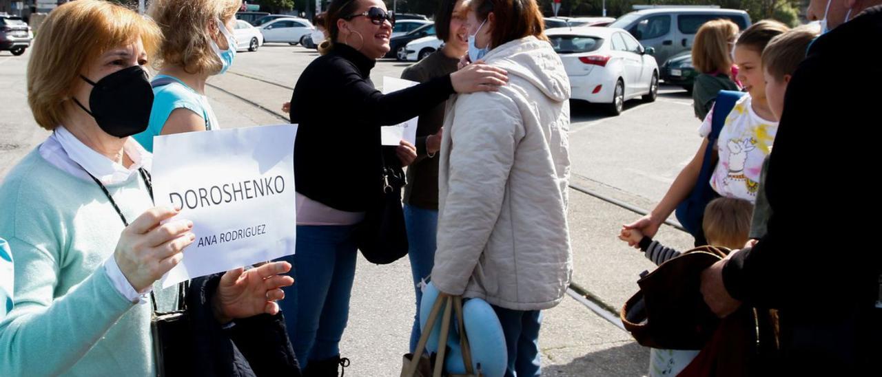 Una mujer sostiene una hoja con el apellido de la persona que espera, ayer en Vilagarcía. |   // IÑAKI ABELLA