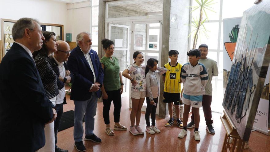 Covadonga Valdés Moré, segunda por la izquierda, junto a los representantes de Amigos del Museo de Bellas Artes, Ada Fernández, y escolares que explicaron el trabajo realizado ante la reinterpretación de la obra «Mineros». | FERNANDO RODRÍGUEZ