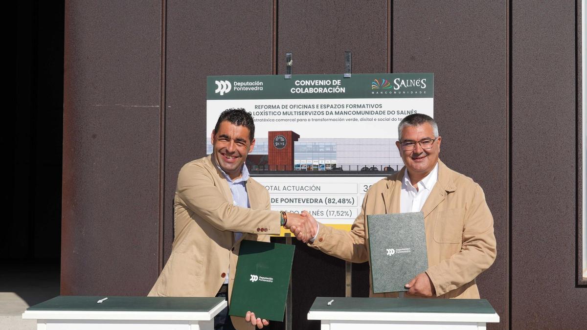 Luis López y David Castro durante la firma del convenio en la nueva nave logística de Cambados.