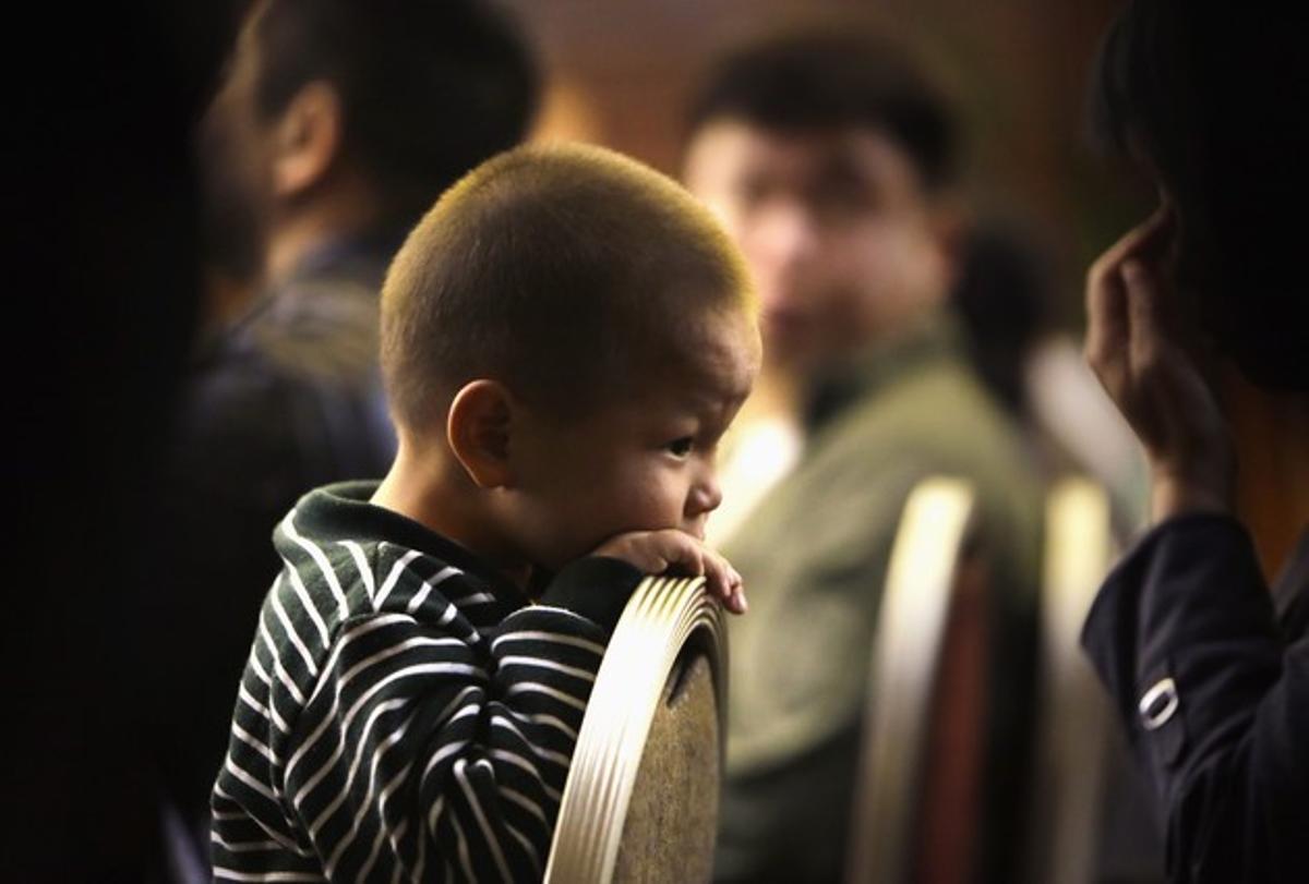 Un nen de tres anys, familiar d’un passatger de l’avió de Malaysia Airlines, espera en un hotel de Pequín, aquest dilluns.