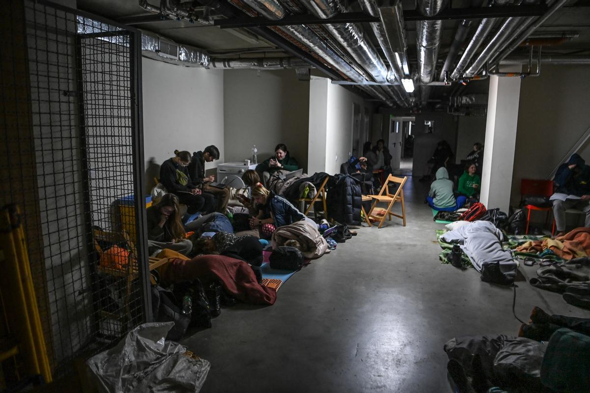 Un grupo de personas duerme en un sótano bajo la Universidad de Lviv tras un bombardeo.