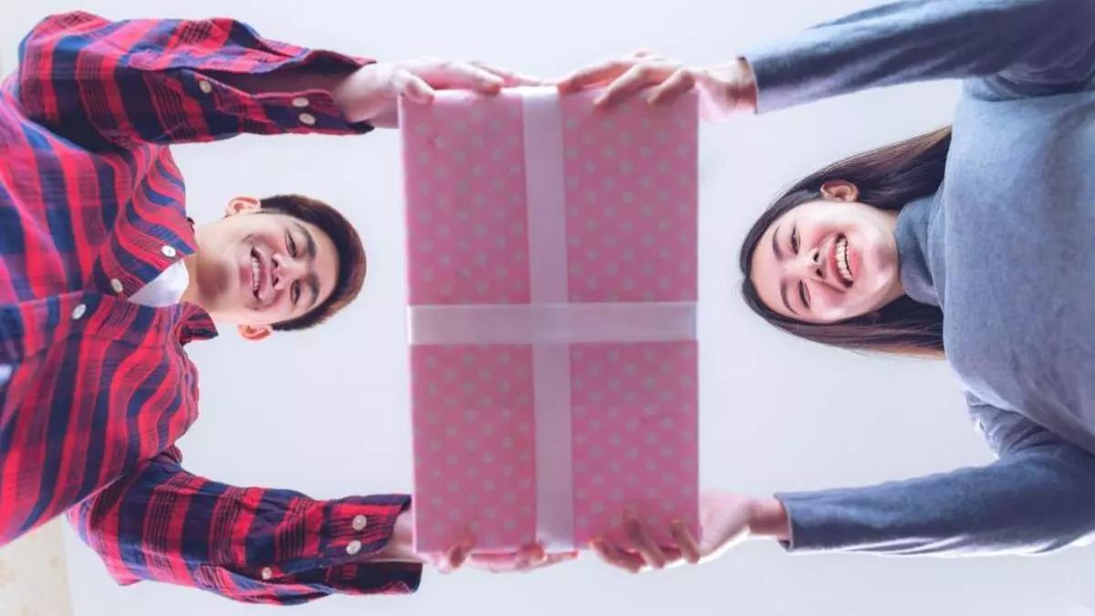 Dos jóvenes sostienen un regalo con sus manos