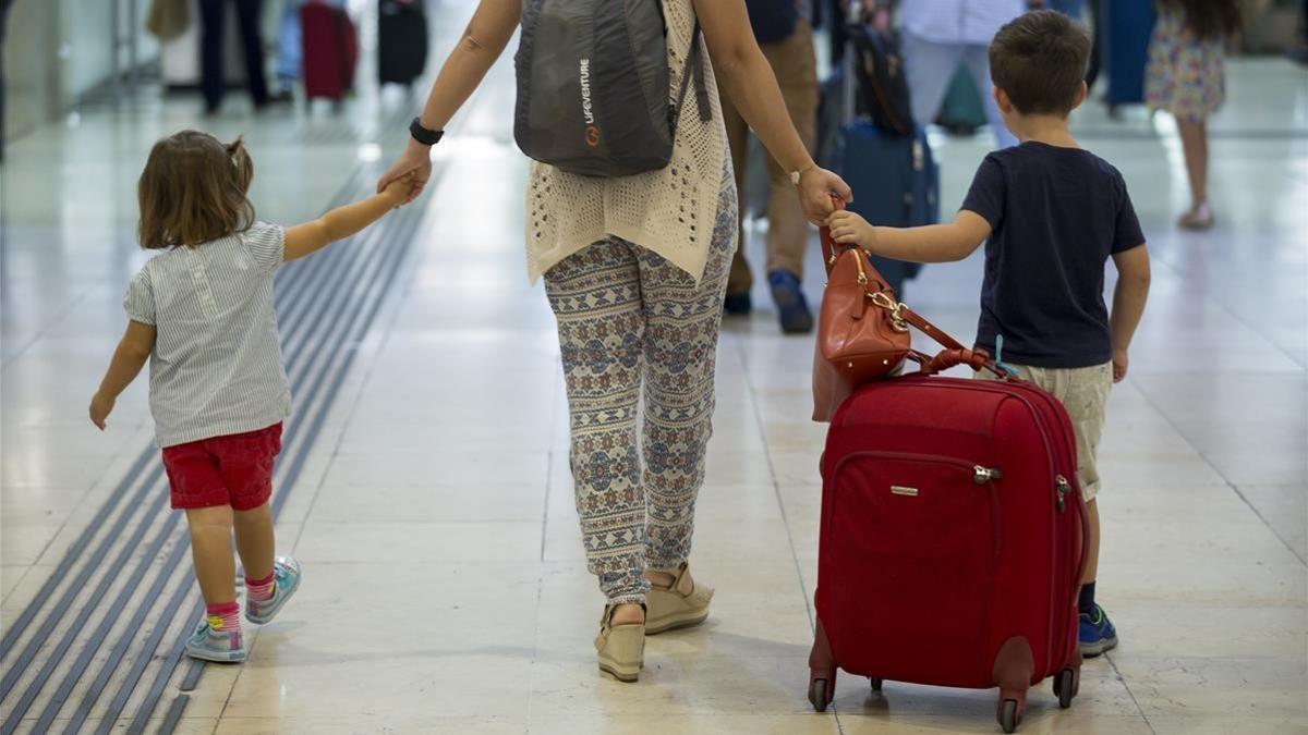 Una mujer acompañada de dos pequeños arrastra una maleta en la estación de Sants, el viernes pasado.