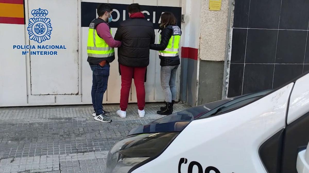 Dos policías, con el joven detenido esta semana por disparar a una casa del clan rival.