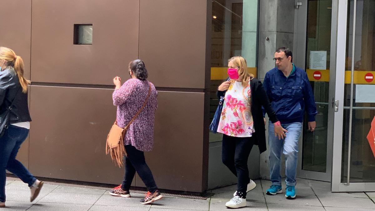 La acusada, con mascarilla roja, sale de la Audiencia.