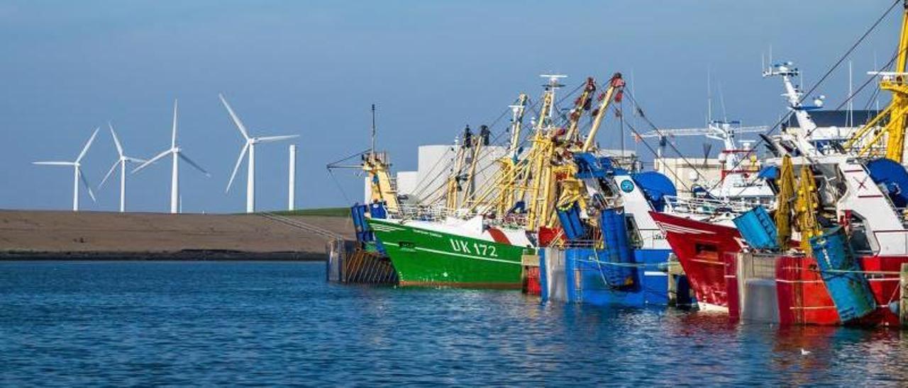 Varios buques de pesca europeos con molinos d viento al fondo