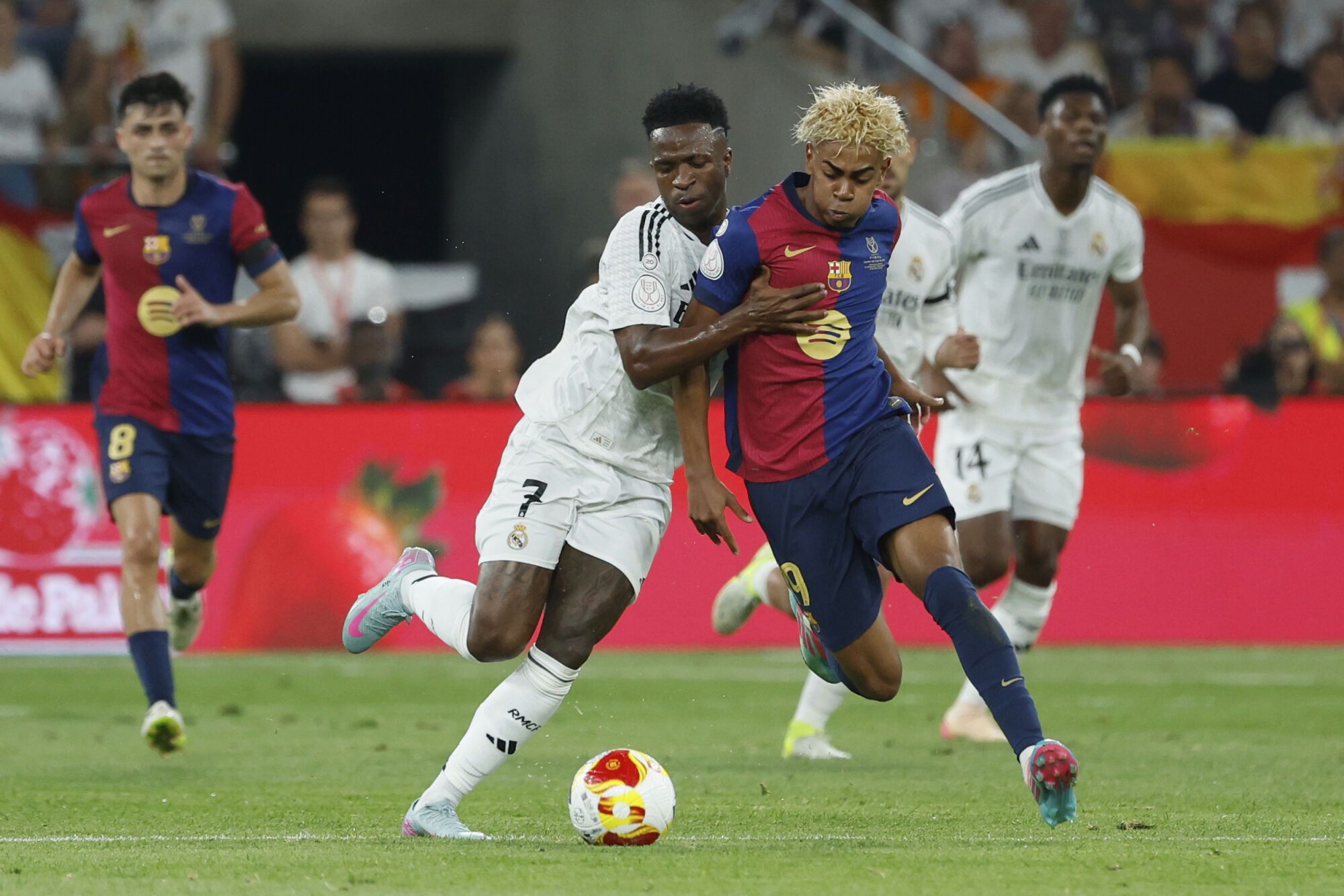 Barcelona's Lamine Yamal, right, fights for the ball with Real Madrid's Vinicius Junior during the Spanish Copa del Rey final soccer match between Barcelona and Real Madrid at Estadio de La Cartuja stadium in Seville, Spain, Saturday, April 26, 2025. (AP Photo/Joan Monfort)