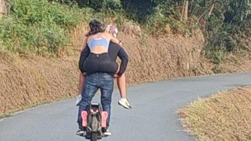 Circula por Arteixo en un monociclo eléctrico con una mujer a hombros