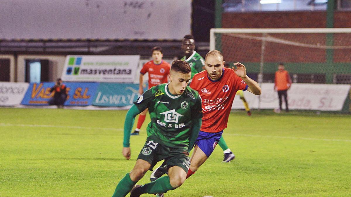 Carlos de Dios persigue a Eimil, ayer durante el derbi entre UD Ourense y Arenteiro en el campo de O Couto. |  // IÑAKI OSORIO