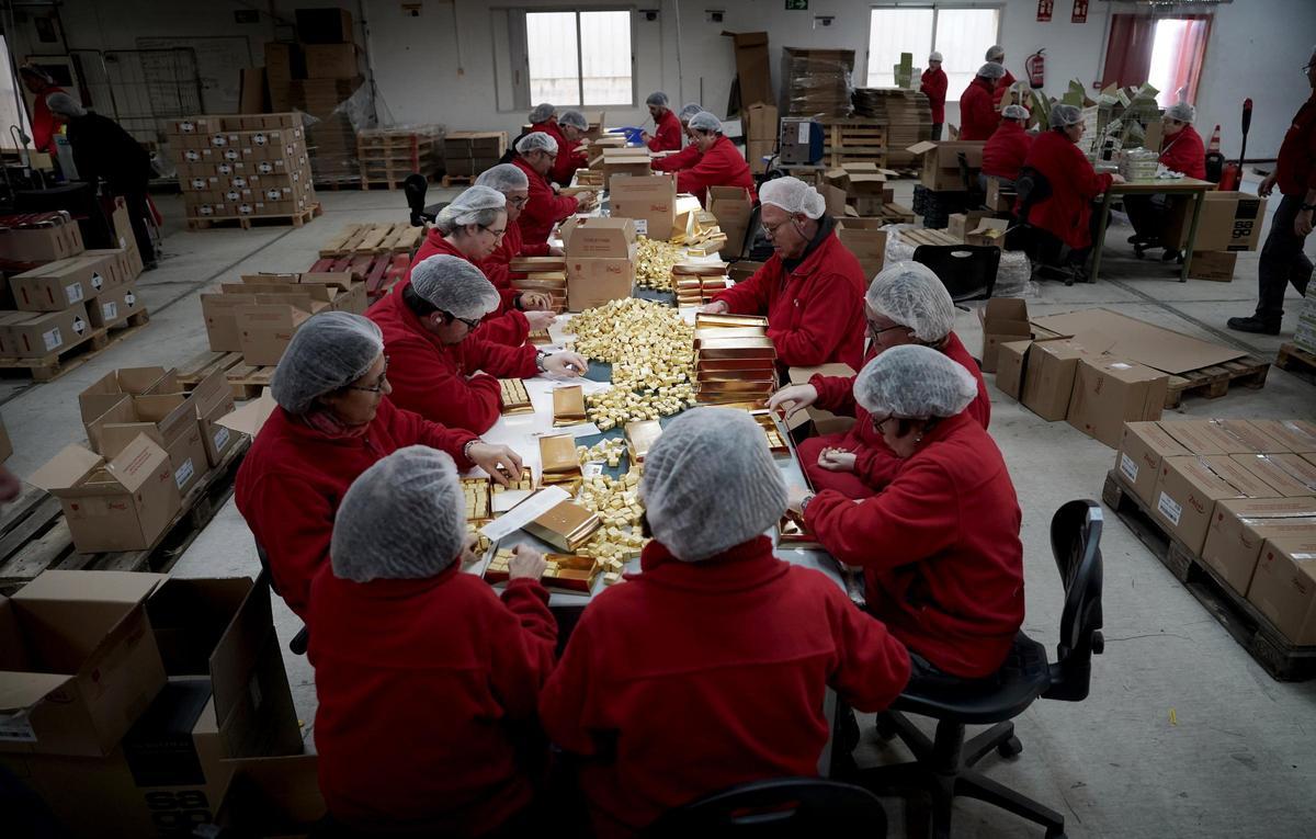 Varias personas con discapacidad elaboran cajas de bombones en el centro de empleo de Envera en Colmenar Viejo (Madrid)