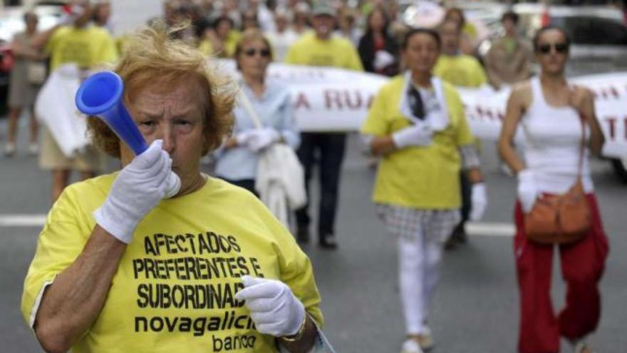 Manifestantes durante la protesta de afectados por la venta de preferentes, ayer en A Coruña. / juan varela