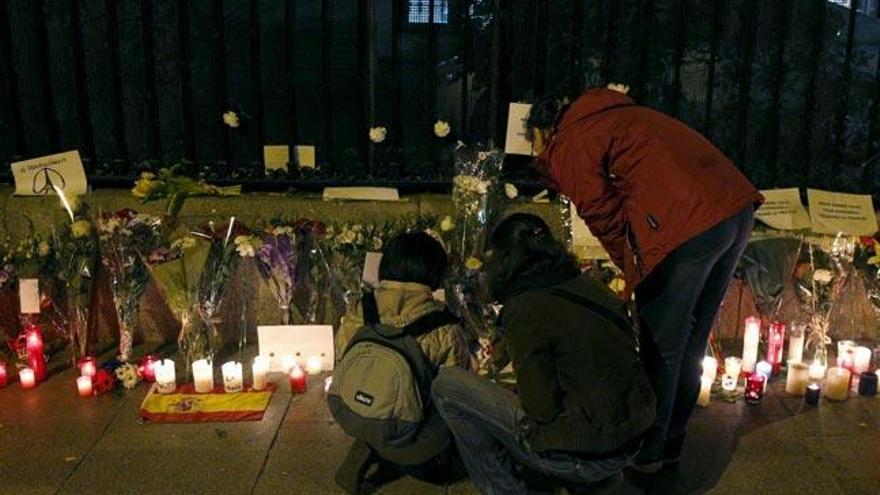 Gente enciende velas y deposita flores en el lugar de los ataques. // Reutters