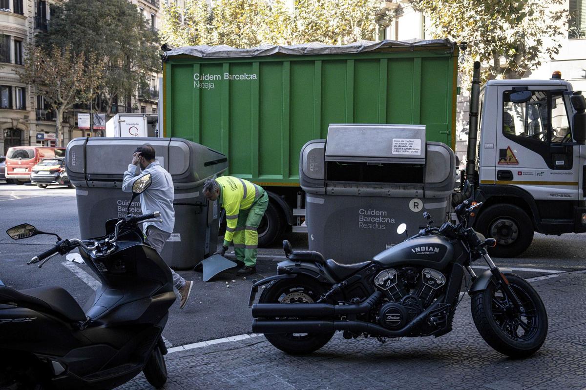Motos aparcadas en una esquina del Eixample frente a contenedores de basura