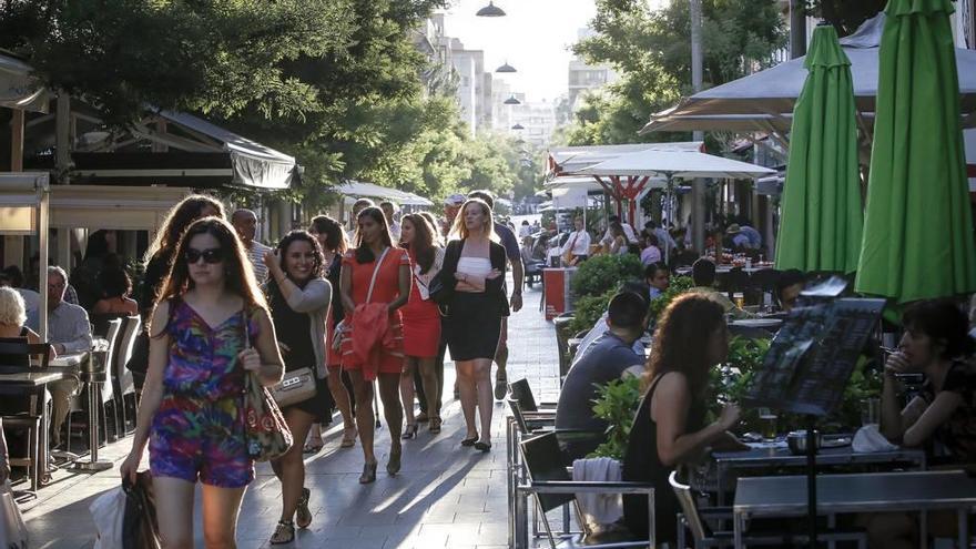 Las terrazas de los bares y restaurantes de la calle Fàbrica invaden ambos lados, por lo que apenas hay espacio para los peatones.