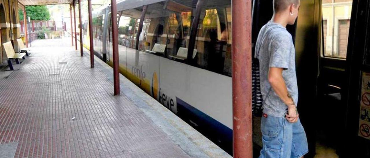 Un viajero se sube al tren en la estación de Sama.