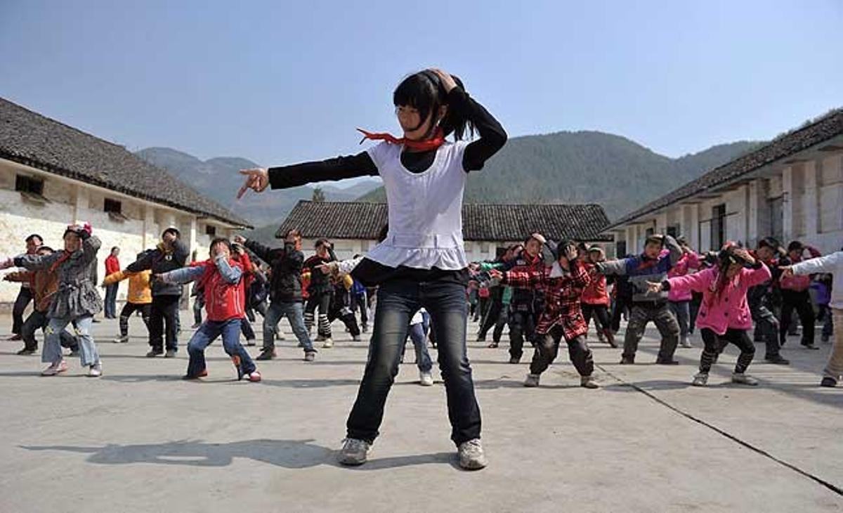 Una nena lidera els altres alumnes d’una escola primària del districte de Wushan (Xina) mentre ballen ’Dangerous’, de Michael Jackson, com a part d’un programa d’exercicis que els 725 nens realitzen cada matí.