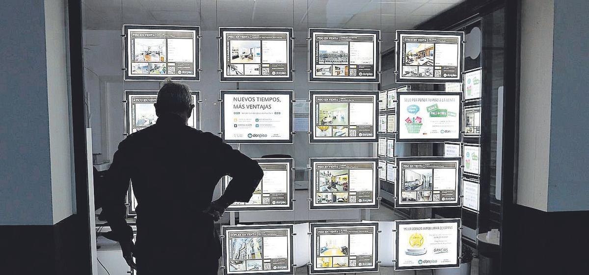Un hombre mira unos carteles en el escaparate de una inmobiliaria de.València.