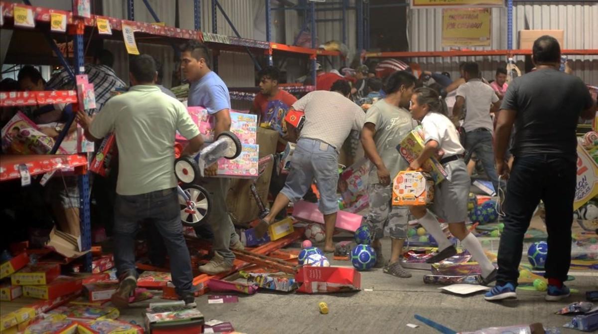 zentauroepp36768198 people pick up toys as they loot a store during a protest in170105115729