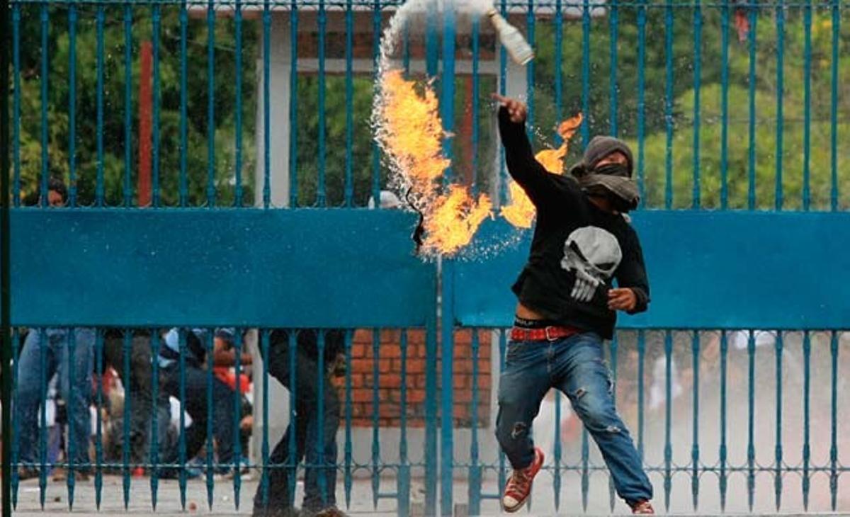 Un estudiant hondureny llança un còctel molotov a la policia durant els enfrontaments entre professors i forces de seguretat. Els estudiants han recolzat els professors en la convocatòria d’una vaga que ha estat declarada il·legal pel govern.