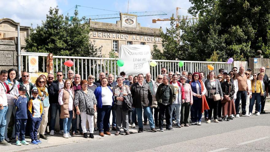 Extrabajadores que forman parte de la nueva asociación, junto a familiares, ante la antigua fábrica de Alfageme en Bouzas.
