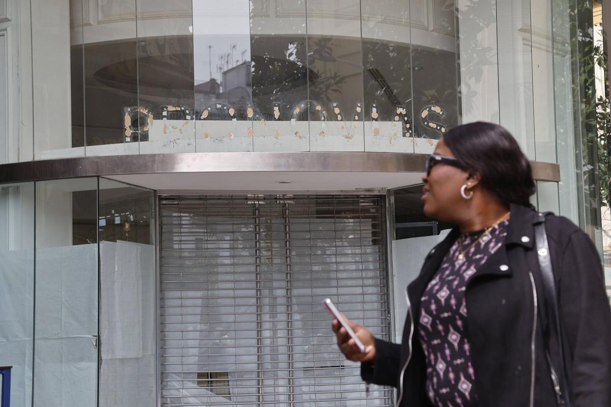 Una mujer pasa junto a la tienda de Pronovias cerrada.