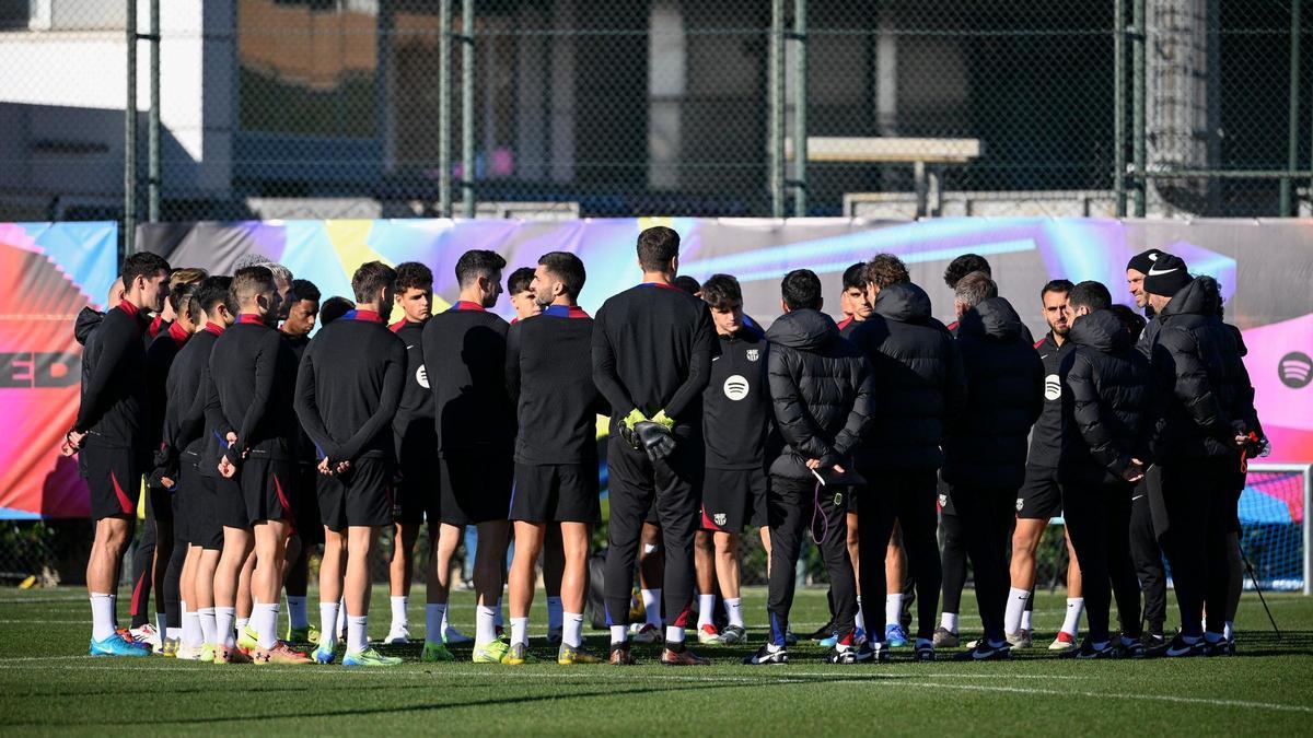 La plantilla del Barça escucha las expliaciones de Hansi Flick antes de empezar un entrenamiento.