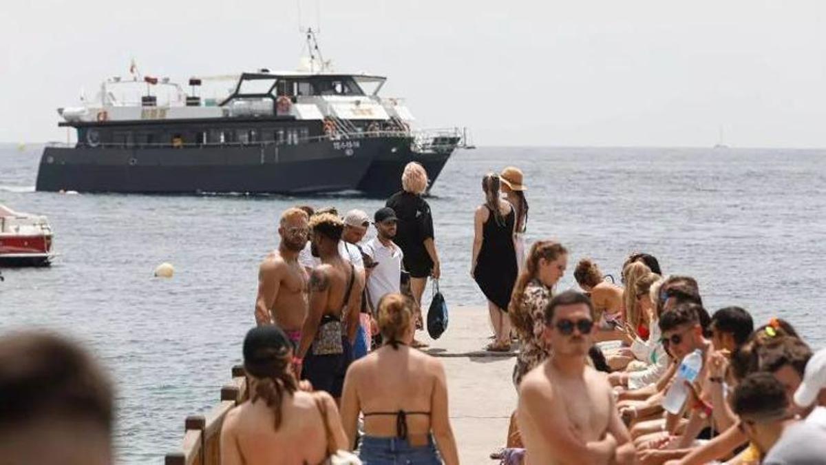 Clientes de un 'party boat' esperan en un embarcadero de la isla.